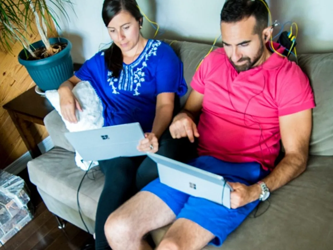 Deux adultes installés dans leur canapé, capteurs posés, pendant une session de neurofeedback à domicile
